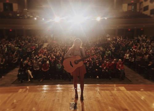 Jessie Chris on stage in packed Franklin Middle auditorium 