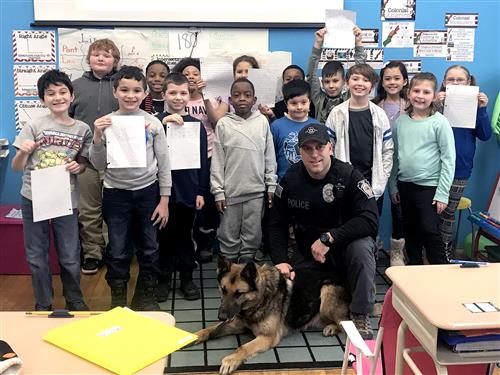 Officer Costello and Tank pose with class 
