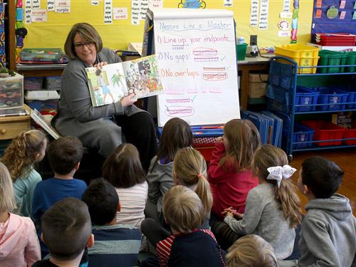 Assistant Superintendent Kelly White reading to students 