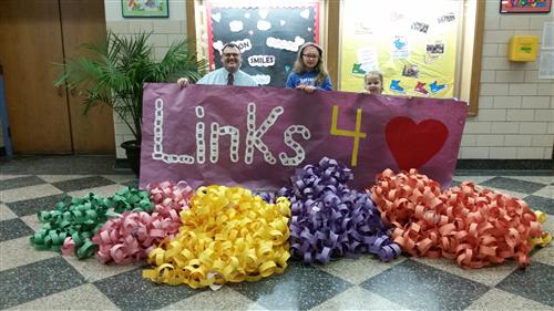 Principal David King and students pose with the Links 4 Love paper chains 