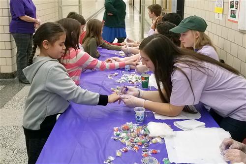 Students have their pinkies painted purple 