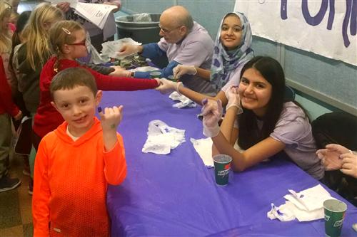 Students have their pinkies painted purple 