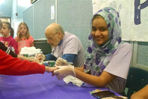 Students have their pinkies painted purple 