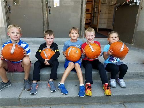 Students holding pumpkins 