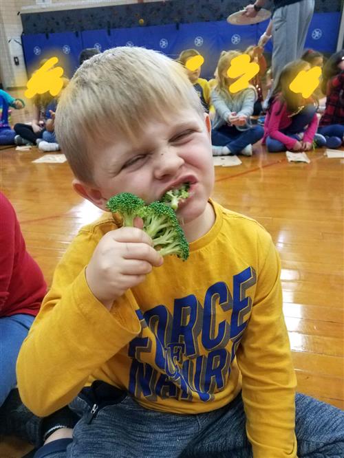 Student eating broccoli 
