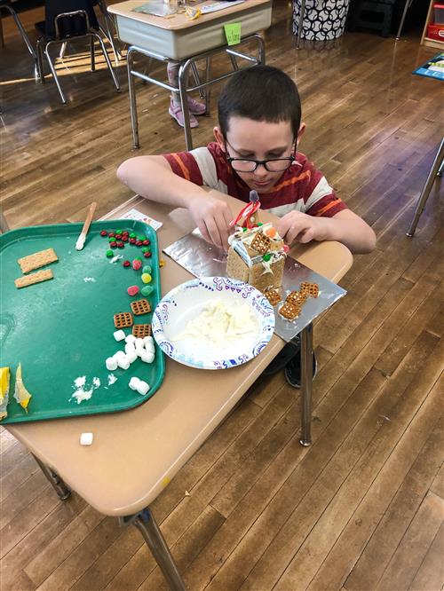 Student works on gingerbread house creation 