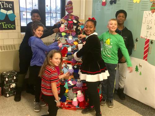 Students stand beside mitten tree 