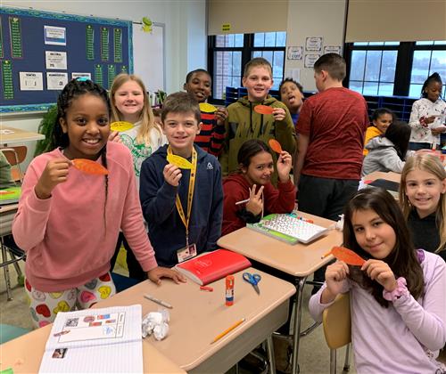Students holding feather shaped empathy messages 