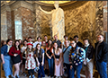 students pose by a sculpture inside a French museum
