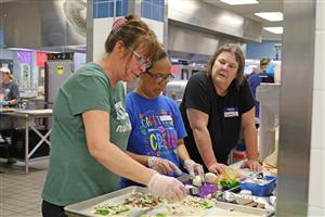 staff members make pizzas
