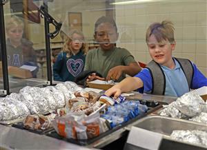 Kids selecting food in a lunch line