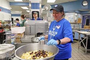 staff member mixes antipasto salad