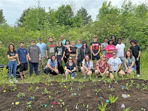 students pose in front of a garden