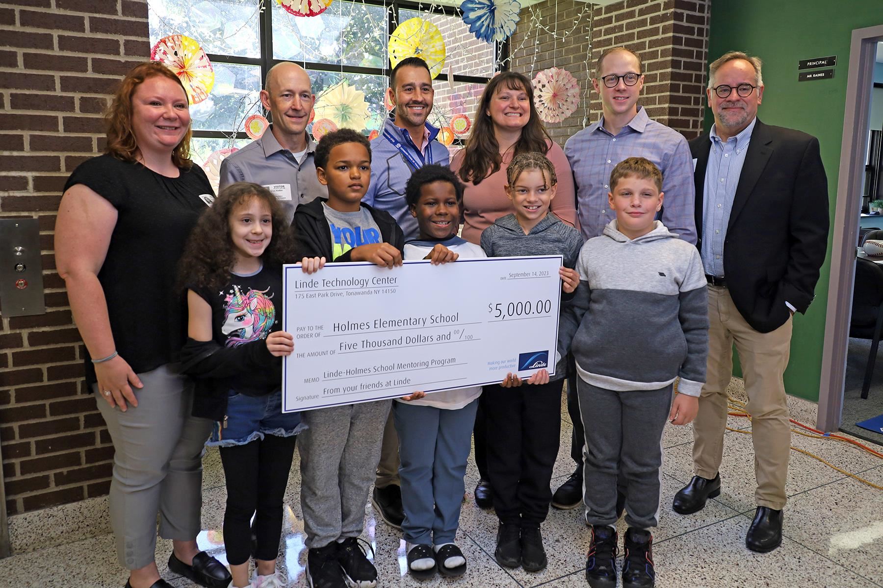 Linde employees and Holmes students with check