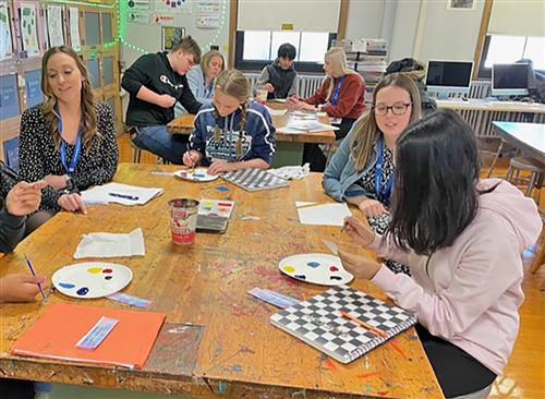 First grade teachers coach students to blend colors to match a unique color