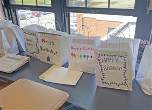 White paper bags filled with birthday goodies.