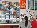  People look at art displays on a wall