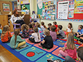  Teacher reads a book to her classroom.