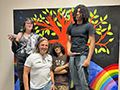  Students and Teacher pose in front of a mural