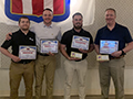  four coaches stand with awards