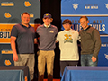 two student athletes and their coaches pose for a picture at their signing day ceremony.