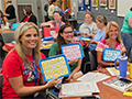  Teachers hold up a alphabet boards during a Phonics lesson