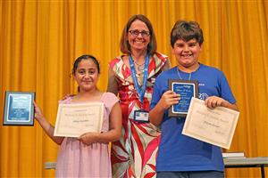 Principal Ann Maccagnano poses with two students at the end of year 4th grade celebration in June 2024